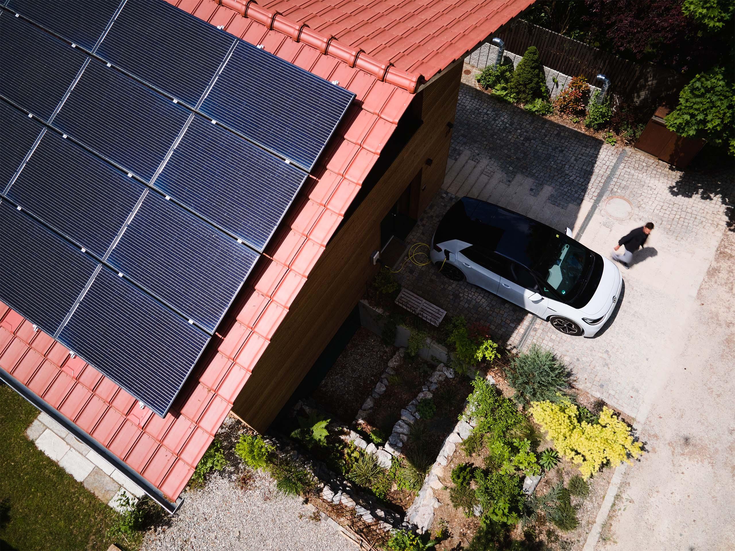 PV Anlage auf Haus mit E-Auto in Einfahrt