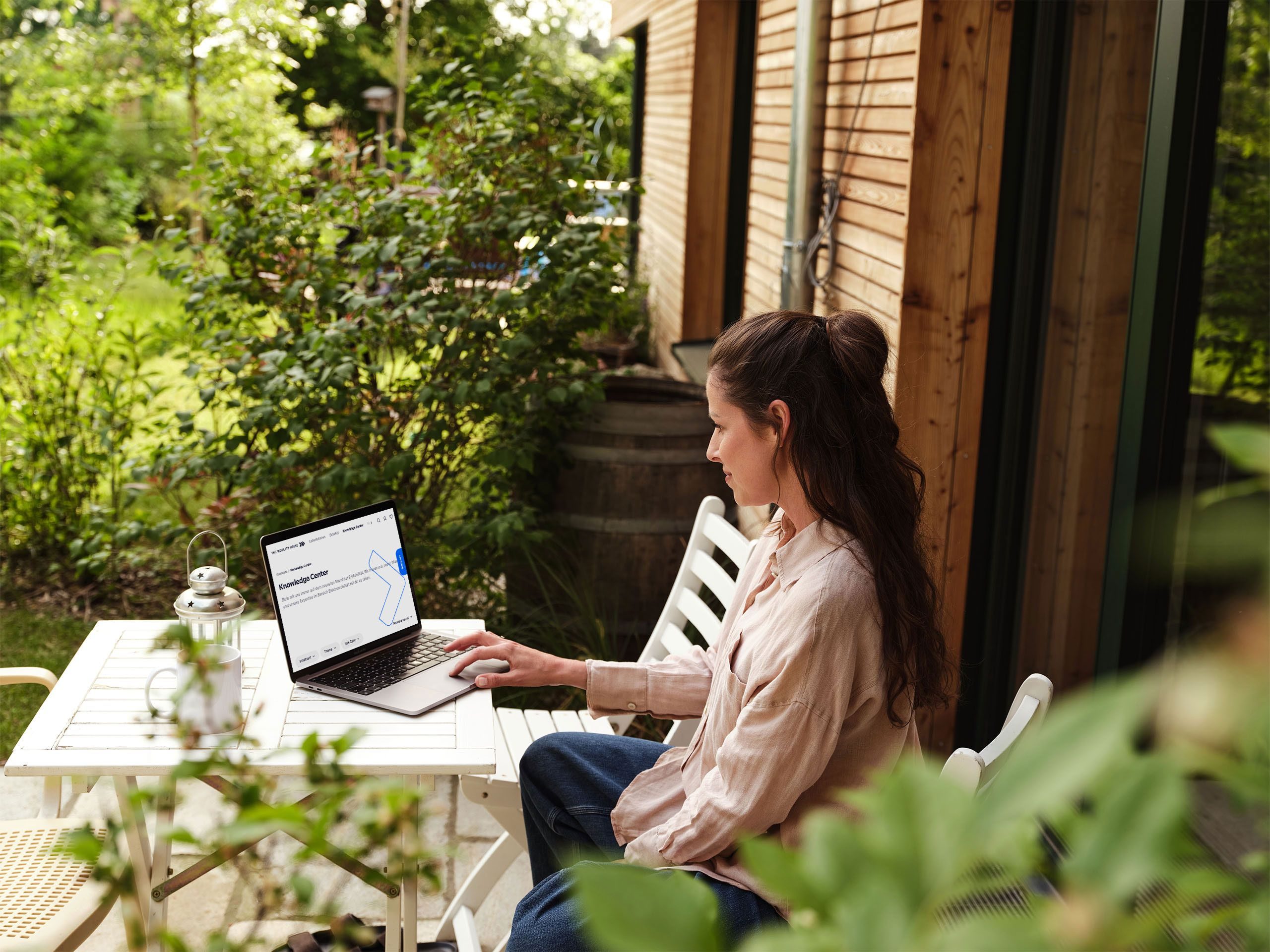 Frau arbeitet am Laptop auf der Terrasse